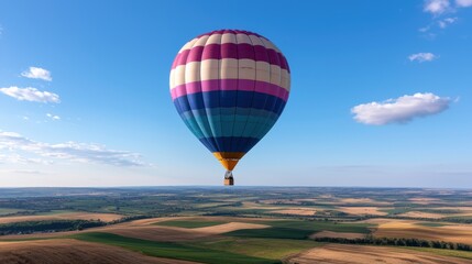 Obraz premium Colorful hot air balloon flying over rural landscape