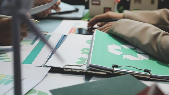 Business people having consultation about wind energy at company office. Business team discussing about windmill and alternative green enery. Net zero and carbon neutral concept