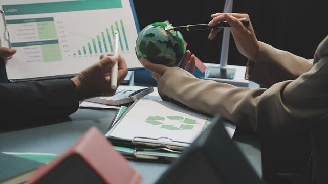Business people having consultation about wind energy at company office. Business team discussing about windmill and alternative green enery. Net zero and carbon neutral concept