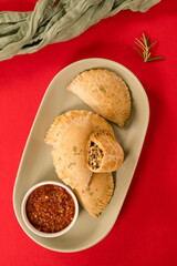 Nigerian Pies on a sage plate against bright red