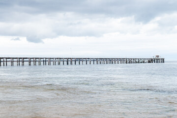 Point Lonsdale Pier stretching into ocean, under a soft overcast sky