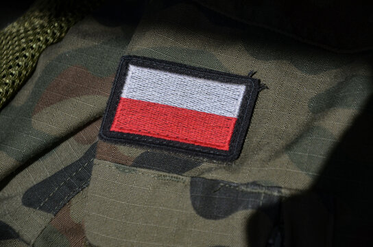 White and red flag of Polish on a camo military uniform