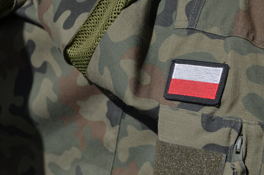 White and red flag of Polish on a camo military uniform