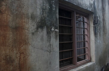 Aged Wall with Barred Window in Rustic Urban Setting