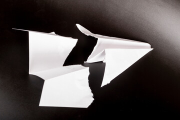 paper plane in the middle it is torn. concept of breakdown, accident, crash, does not work....