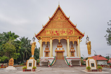 Naklejka premium A beautiful view of a temple that has two buddha statues on the entrance located in the southern of Wat Pha That Luang, Vientiane, Laos
