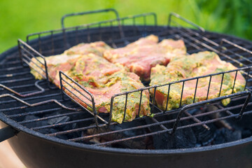 Backyard BBQ with Prepared Meat Ready for Grilling. Charcoal Kettle Grill Loaded with Seasoned Cuts in Wire Basket