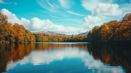 Stunning Autumn Landscape Over Calm Lake with Vibrant Trees and Blue Sky