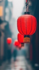 Obraz premium Beautiful red lanterns hanging in a misty alley, creating a tranquil and atmospheric scene in a bustling city.