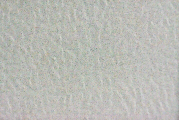 White tile floor with small multi-colored dots scattered all over the surface. Rough texture. White back. Abstract background.