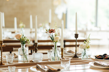 Elegant neutral coloured wedding table scape with flowers and candles