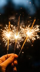 A hand holding three sparkling sparklers, illuminating the twilight sky, perfect for celebrations and festive occasions.