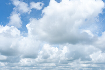 Fluffy white clouds drift across a bright blue sky, painting a breathtaking cloudscape © Sloek Prey