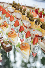 A large selection of various snacks for guests on a mirror surface. Buffet before an important event