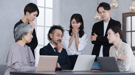 Multiple businessmen and women working in teams looking at computers Negative images of thinking suffering from declining performance and sales.