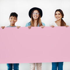 Team, happy women and portrait with banner for advertising, space and diversity in studio. Group, poster and girls with sign for mockup, business marketing or creative placeholder on white background