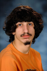 people of ai // yearbook school photo of unattractive boy with black hair and mustache, orange shirt, photorealistic