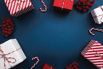 A circle of presents, candy canes, and berries on blue