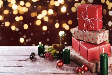 Colorful Christmas presents and candles on a wooden table