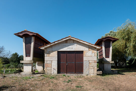 Dois pequenos espigueiros e uma pequena casa de arruma&ccedil;&atilde;o com a descri&ccedil;&atilde;o na fachada frontal em portugu&ecirc;s, Eira da Laigela MMXVIII, no concelho de Viseu em Portugal