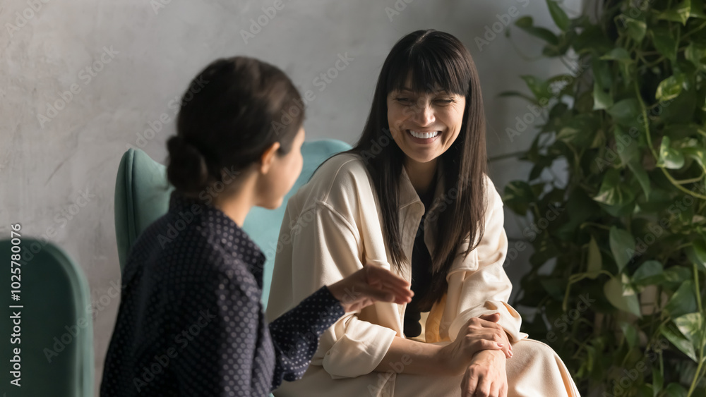 Canvas Prints cheerful diverse middle aged business woman talking to colleague on office work break, sitting in ar