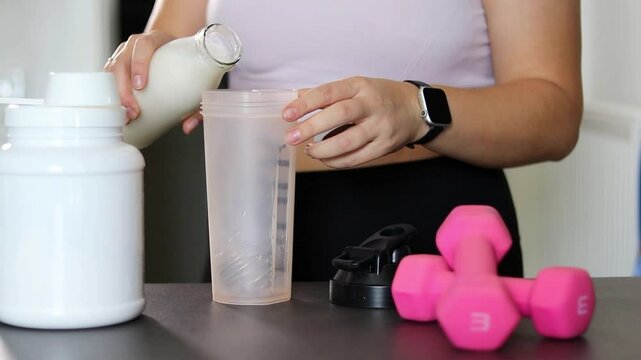 Close up of woman preparing a protein shake in the kitchen. Diet meal replacement for weight loss 