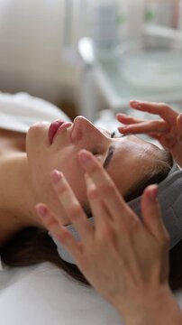 A beautiful woman enjoys a facial massage at a spa salon,indulging in skin and body care treatments.