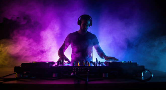 Vibrant nightclub dj in action with colorful stage lights