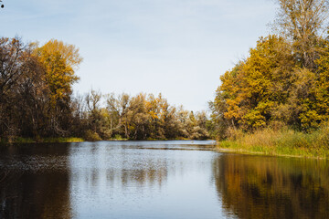 Autumn, a lake, a beautiful landscape, a calm surface of water, a light breeze blows on the surface of the reservoir.
