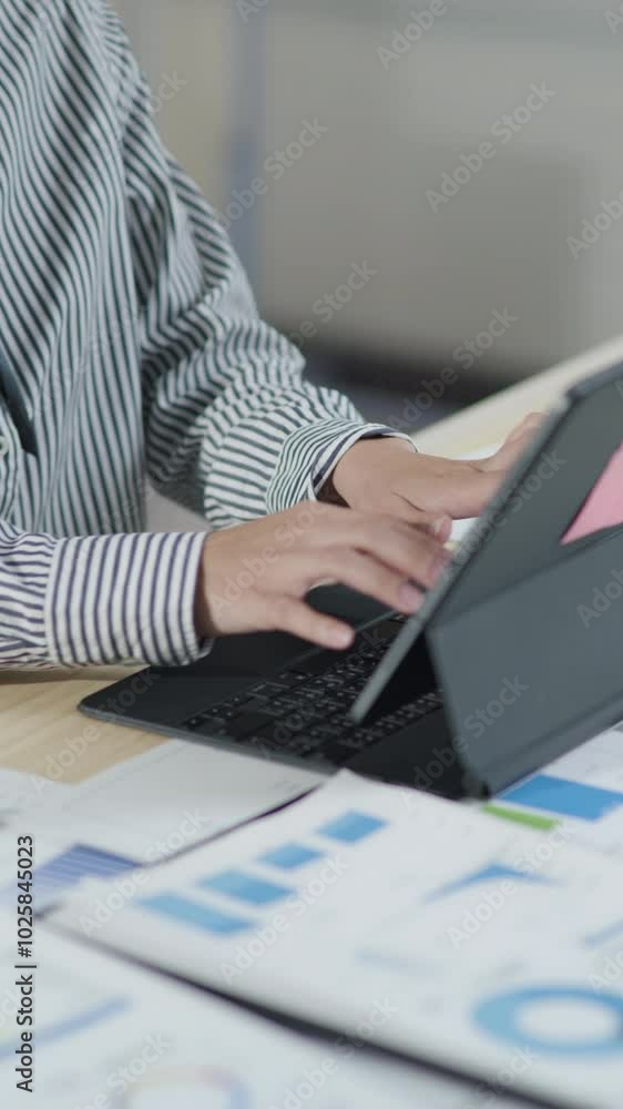 Poster vertical footage of businesswoman is working and typing on tablet keyboard and calculator for cost w