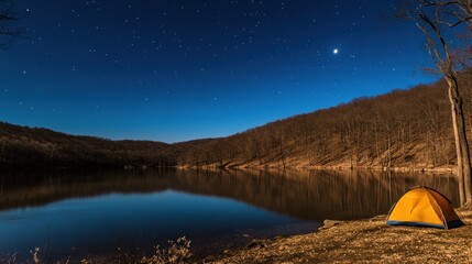 A lone yellow tent sits on the shore of a still lake under a starry sky.