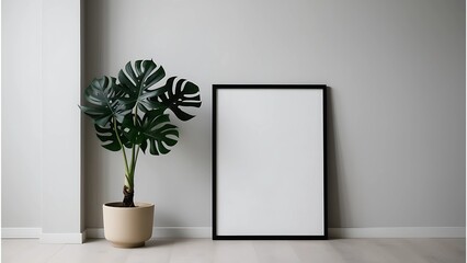 Minimalist Interior Design with a Blank Black Frame and Monstera Plant Against a Wall