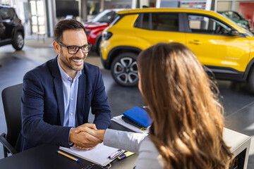 Young woman signing car insurance document or lease paper contract or agreement. Buying or selling...