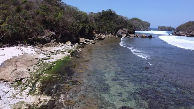 Peh Pulo Beach is located in the tropics, has white sand and a very blue sky.