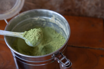 Matcha green tea powder in a white spoon