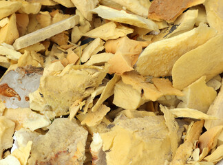 Old pieces of foam rubber scattered on the ground in a workshop, highlighting their varied shapes and textures from years of use