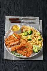breaded pork cutlet with fries, broccoli on plate