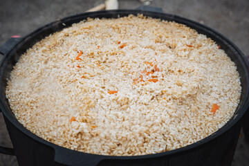 In a sturdy pot, fluffy and perfectly cooked rice is held, artfully mixed with vibrant carrots, creating a dish that is visually stunning and perfect for any meal or special occasion