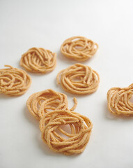 Murukkus spread out against a plain white background, showcasing their crisp, golden texture.