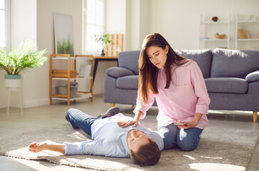 Stressing moment man falls into faint leaving lovely woman. Woman calling ambulance by phone man in faint lying down at floor seeking aid for his unexpected collapse Faint at home apartment