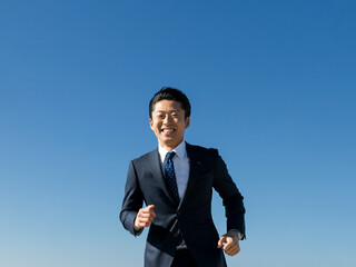 笑顔で走るビジネスマン, 青空
