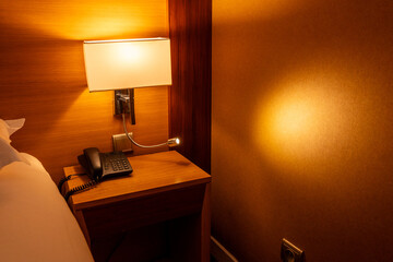 bedside table telphone and lamp at a hotel room