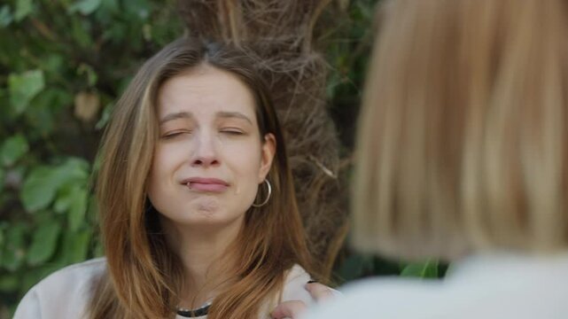 Broken hearted. A beautifully captured moment where a woman cries and openly expresses her raw emotions during an outdoor conversation.
