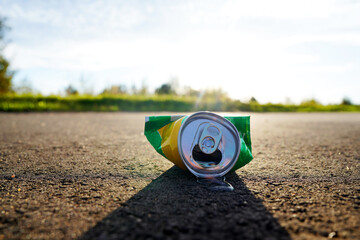 Crumpled soda can on asphalt with drink spilled. Discarded broken carbonated drink tin can on asphalt road. Problem social, crime. Thrown out Crushed juce. Crumpled Beer Can Crushed. Spilled drink.