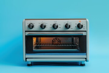 Obraz premium Silver countertop toaster oven with illuminated interior against a blue background