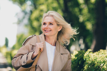 Portrait of attractive senior dreamy female resting strolling enjoy weekend wondered walk wear...