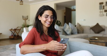 30s Brazilian woman spend pastime at home holding smartphone exchanging audio messages using voice typing, enjoy communication with chat bot, using virtual assistant, recording quick note or reminder