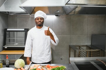 African American chef cooking tasty salad in kitchen