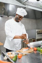 Gourmet chef in uniform cooking in a commercial kitchen.