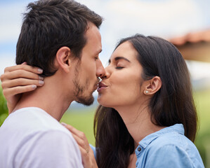 Fototapeta premium Happy, kissing and couple with love in nature on romantic date for vacation, getaway or weekend trip. Smile, park and man and woman with connection, care and bonding outdoor in garden on holiday.